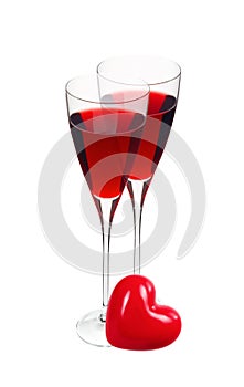 Two glass with red wine and red heart isolated on white