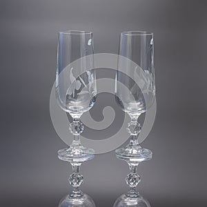 Two glass tall glasses for wine on a black background.