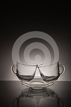 Two glass for tea and an empty saucer on a black and white background