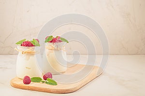 Two glass yogurt with raspberry and mint/two glass yogurt with raspberry and mint on a wooden tray, selective focus and copy space