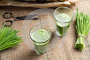 Two glasses of barley grass juice with fresh barley grass blades