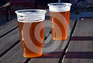 Two glasses of beer in the sunlight on the outdoor terrace