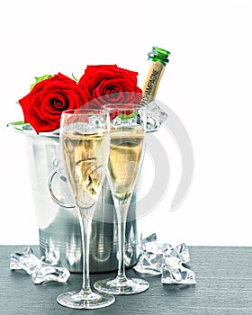Two glasses, bottle of champagne and red roses