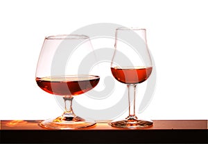 Two glasses with brandy on a white background