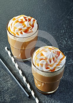 Two glasses of caramel latte with whipped cream