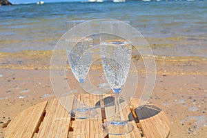 Two Glasses Of Champagne On The Beach With Sea Bac