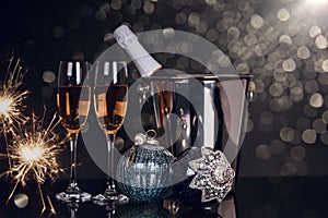 Two glasses with champagne, bottle and Christmas ornaments