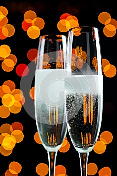 Two glasses with champagne bubbles on an abstract background