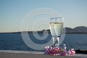 Two glasses with champagne or cava served outside on terrace, lu