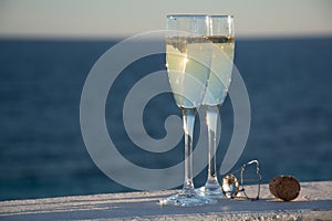 Two glasses with champagne or cava served outside on terrace, lu