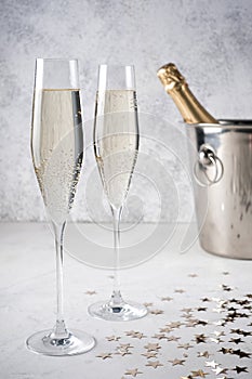 Two glasses of champagne with a champagne bottle in a bucket