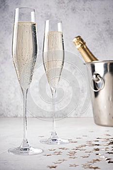 Two glasses of champagne with a champagne bottle in a bucket