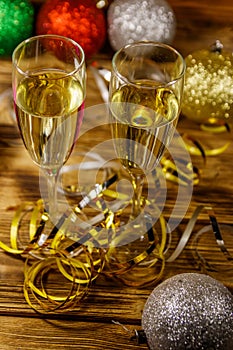 Two glasses of champagne and festive Christmas decorations on wooden table