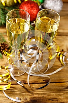 Two glasses of champagne and festive Christmas decorations on wooden table