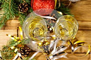 Two glasses of champagne and festive Christmas decorations on wooden table