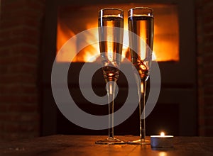 Two glasses of champagne in front of fire