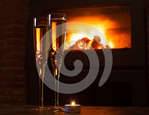 Two glasses of champagne in front of fire