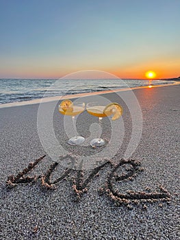 Two glasses of champagne for romantic evening on the beach at sunset