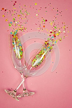 Two glasses champagne rosy spilled colored candies