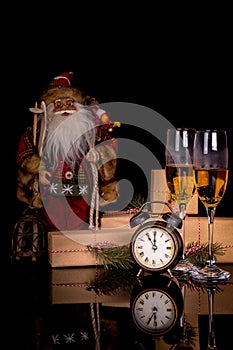 Two glasses with champagne, Santa Claus and christmas gifts