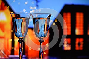 Two glasses with champagne sparkling wine on a festive background with lights and bokeh.