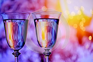 Two glasses with champagne sparkling wine on a festive background with lights and bokeh. Atmosphere of celebration,