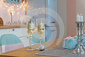 Two glasses of champagne surrounded by Christmas New year background and decoration, light bokeh effect and light garland