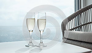 Two glasses of champagne on table of cruise ship suite.