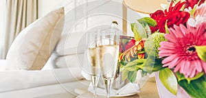 Two glasses of champagne in the upscale hotel room. Dating, romance, honeymoon, valentine, getaway concepts