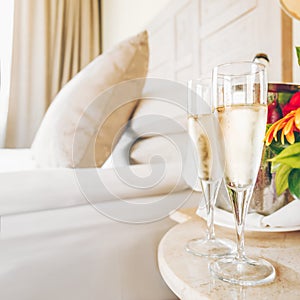 Two glasses of champagne in the upscale hotel room. Dating, romance, honeymoon, valentine, getaway concepts