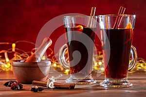 Two glasses of christmas mulled wine with spices on wooden table