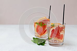 Two glasses of Cocktail grapefruit with fruits.