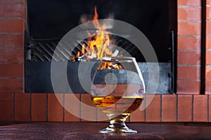 Two glasses of cognac on old brick fireplace