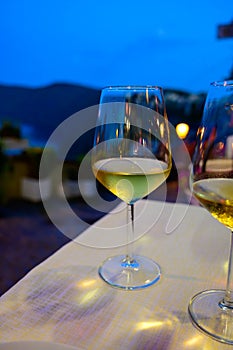 Two glasses of cold dry white wine served outdoor in cafe at night in Italy