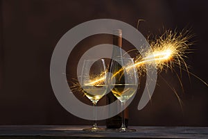 Two glasses containing wine with wine bottles are decorated with sparkling fireworks