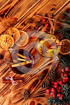 Two glasses cups of red and white mulled wine or gluhwein with spices and orange slices on rustic wooden table top view