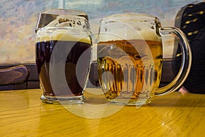 The two glasses of czech beer on a wooden barrel table