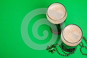 Two glasses of dark stout beer and traditional clover shaped decor