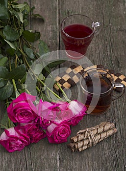 Two glasses of drink, cookies and bouquet of scarlet red roses