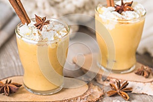Two glasses of eggnogg with whipped cream and cinnamon