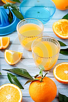 Dos anteojos de fresco jugo gatito a maduro fresco naranjas sobre el azul de madera mesa fresco naranja jugo creación 