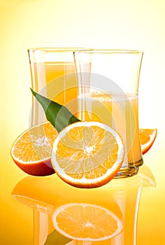 Two Glasses of Fresh Orange juice, half oranges