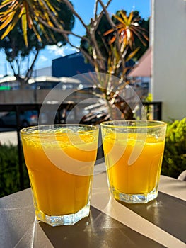 Two glasses of fresh orange juice on a table, Zumo fresco de Naranja photo