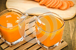 Two glasses of homemade carrot juice on wooden background/Two glasses of homemade carrot juice on wooden background. selective