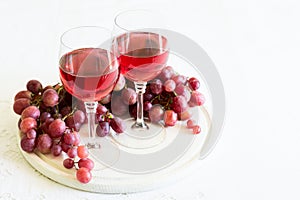 Two glasses of homemade rose wine and grapes