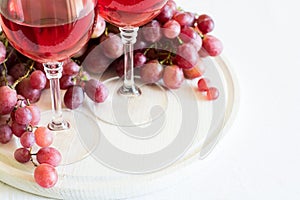 Two glasses of homemade rose wine and grapes