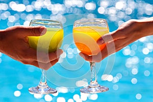 Two glasses with juice against blue water