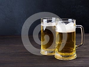 Two glasses of lager served on old wooden planks, copyspace for text
