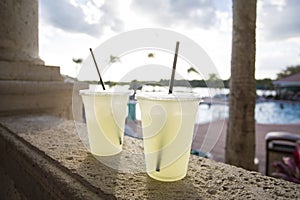 Two glasses of lemonade poolside at a tropical resort