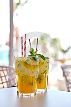 Two glasses of mojito cocktails on table in summer terrace